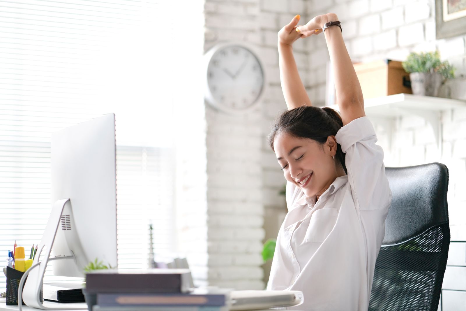 Femme qui s'étire dans son bureau