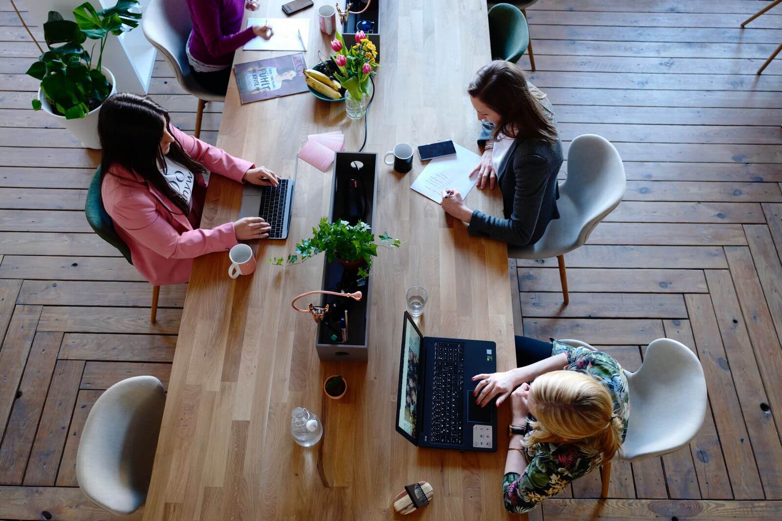 Female workers sitting at large office table