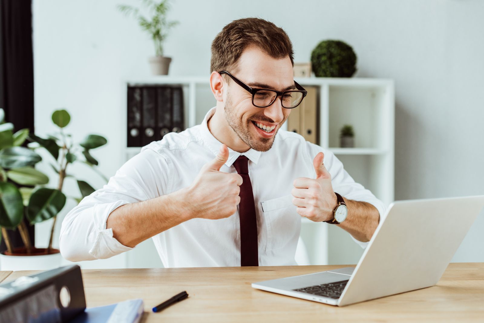 Businessman giving thumbs up on videoconference call