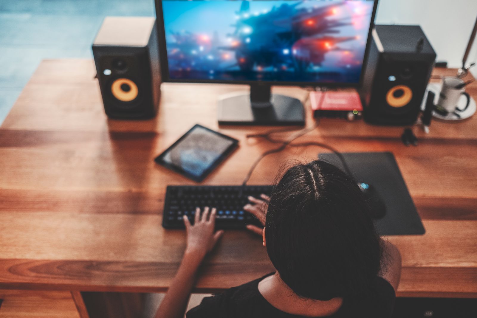 Woman playing video games on large desk surface