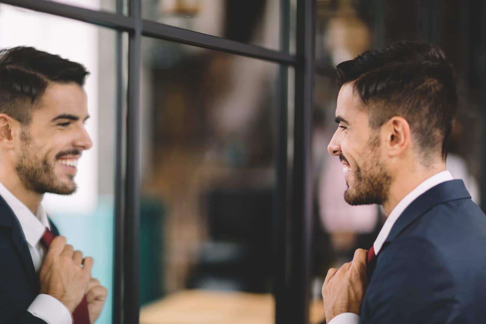 Man wearing a suit looking in the mirror