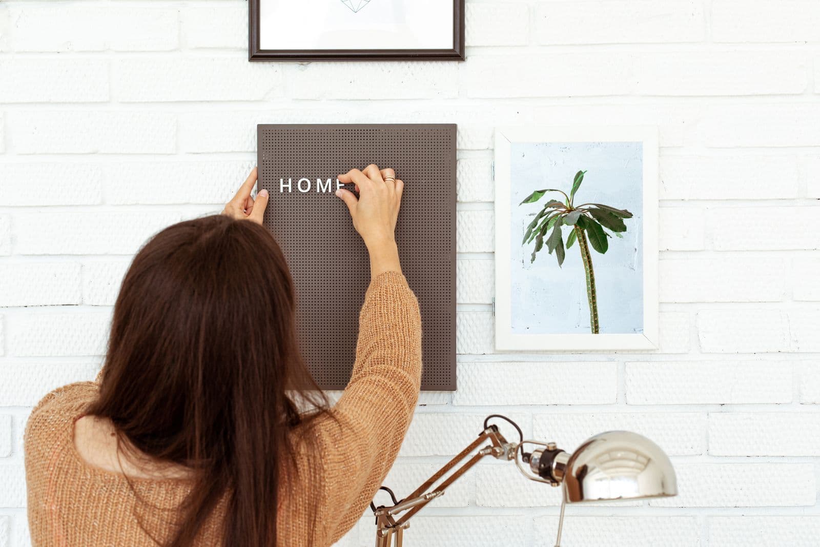 Woman decorating her home office with a letter board.