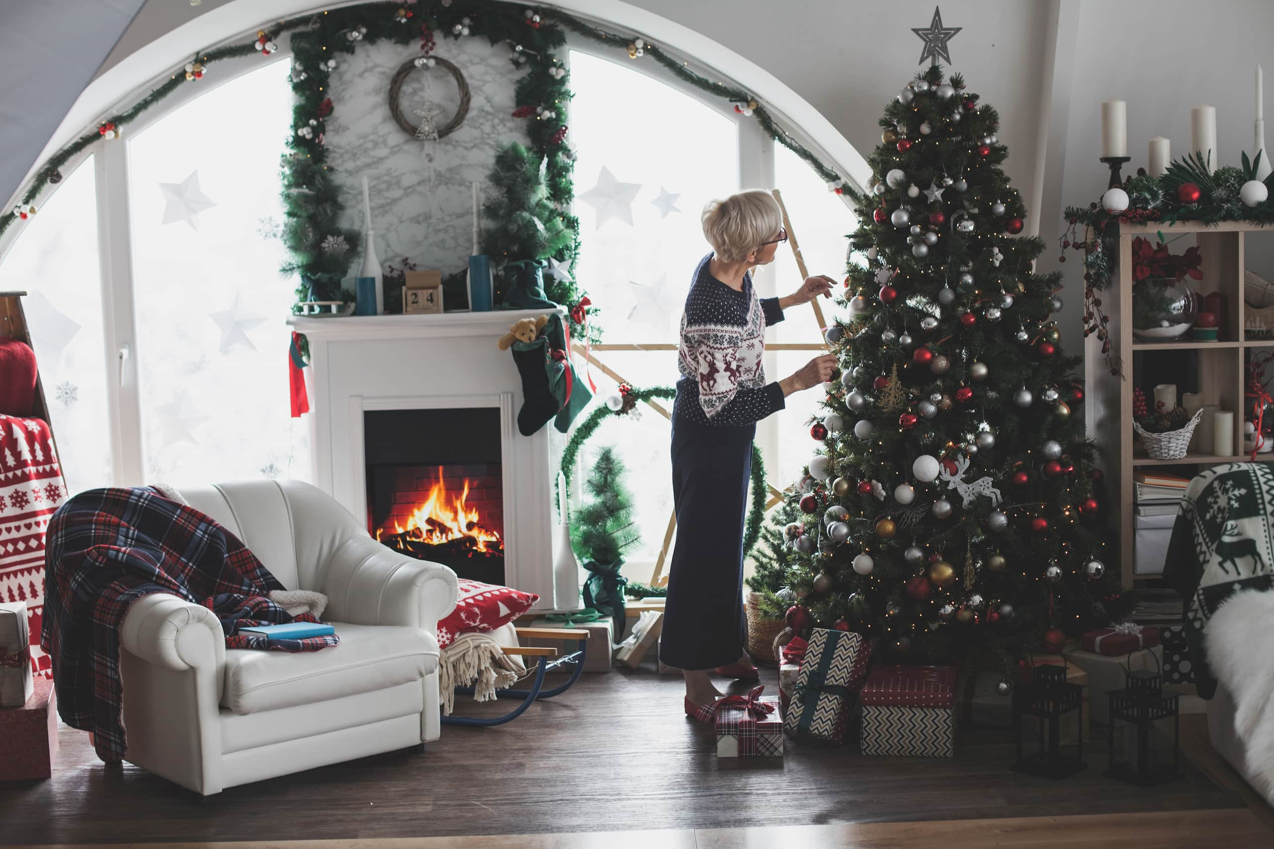 Femme qui décore un sapin de Noël