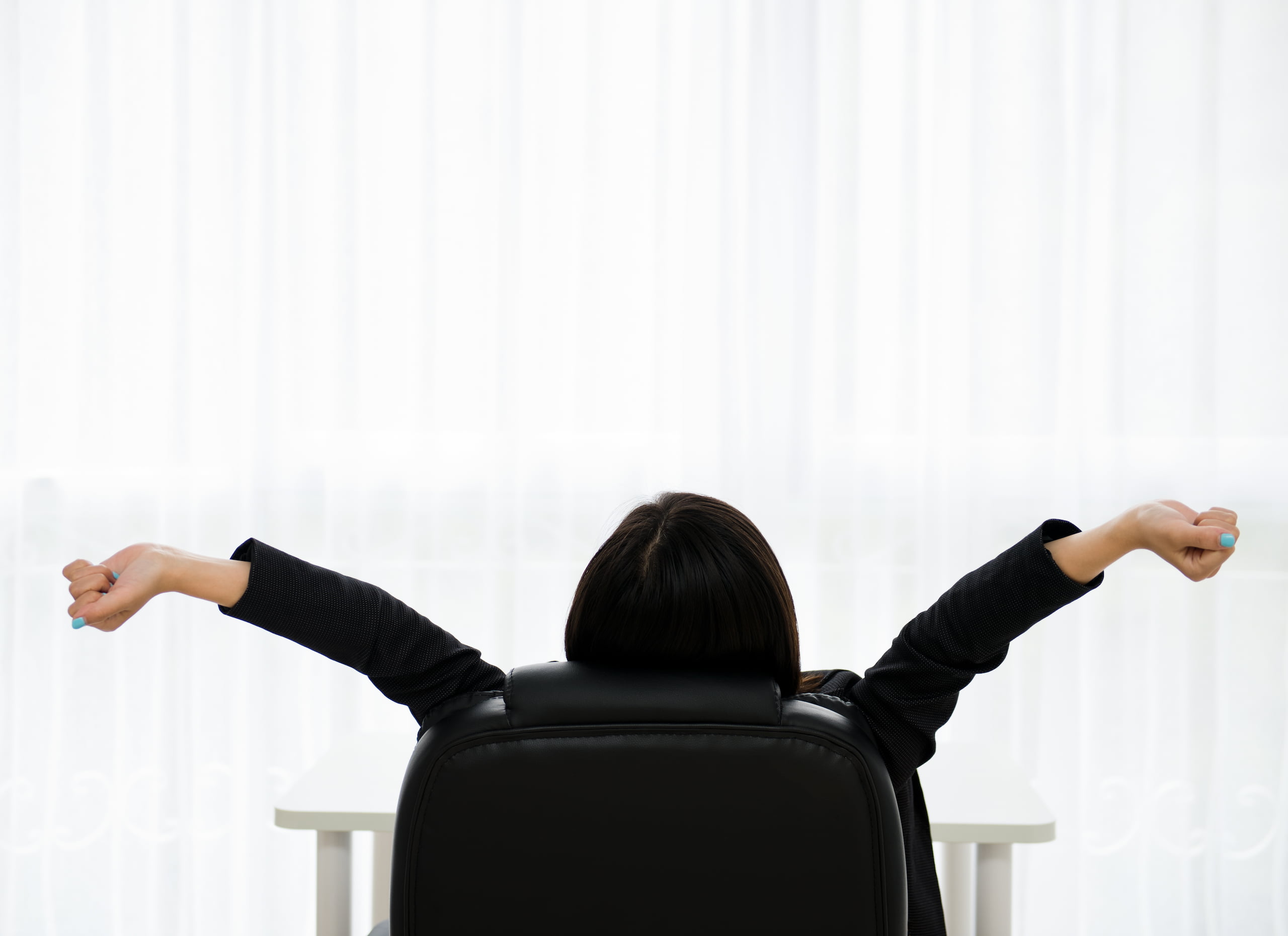 Femme qui s'étire sur sa chaise de bureau