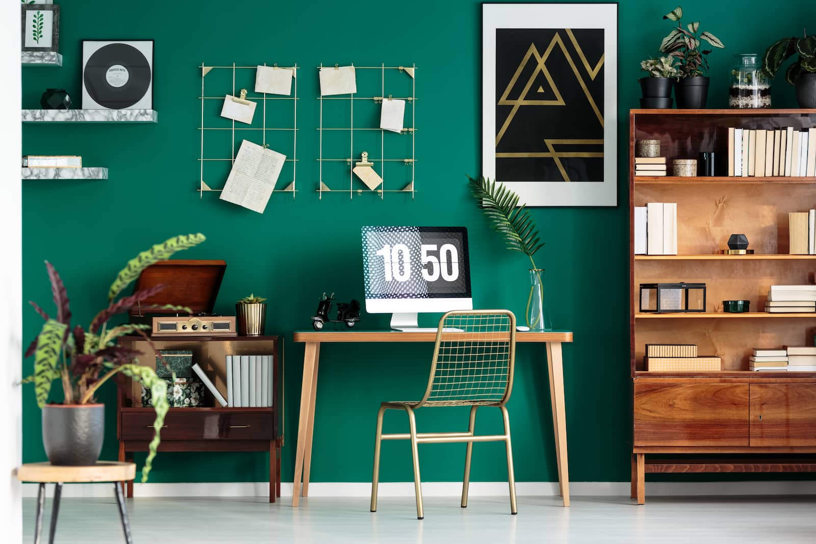 small desk next to green wall and decorations