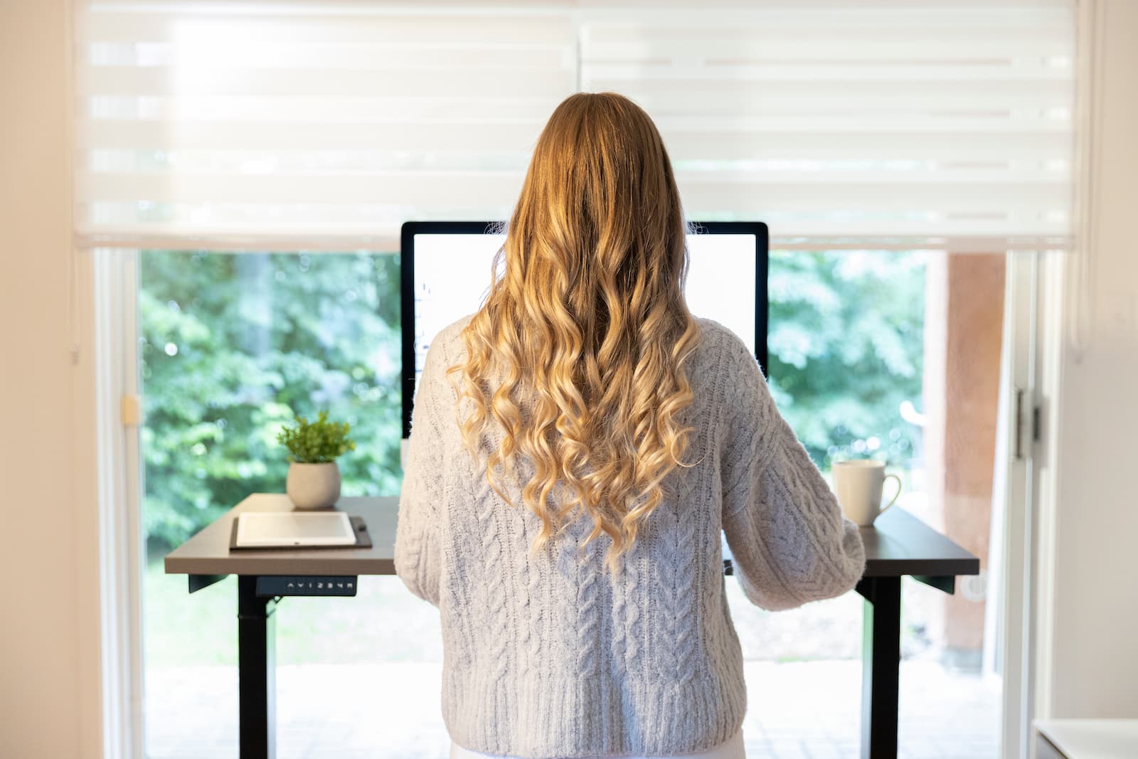 Jeune femme qui utilise le meilleur bureau assis-debout au Canada