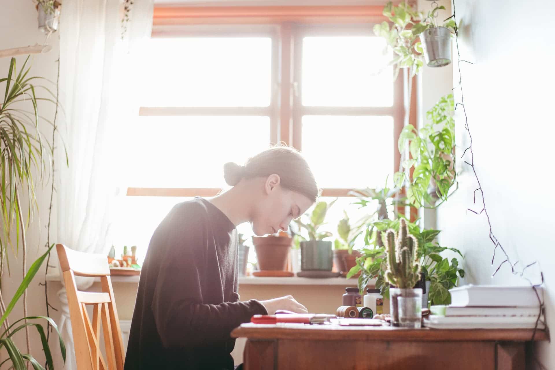 Femme à un bureau avec plusieurs plantes
