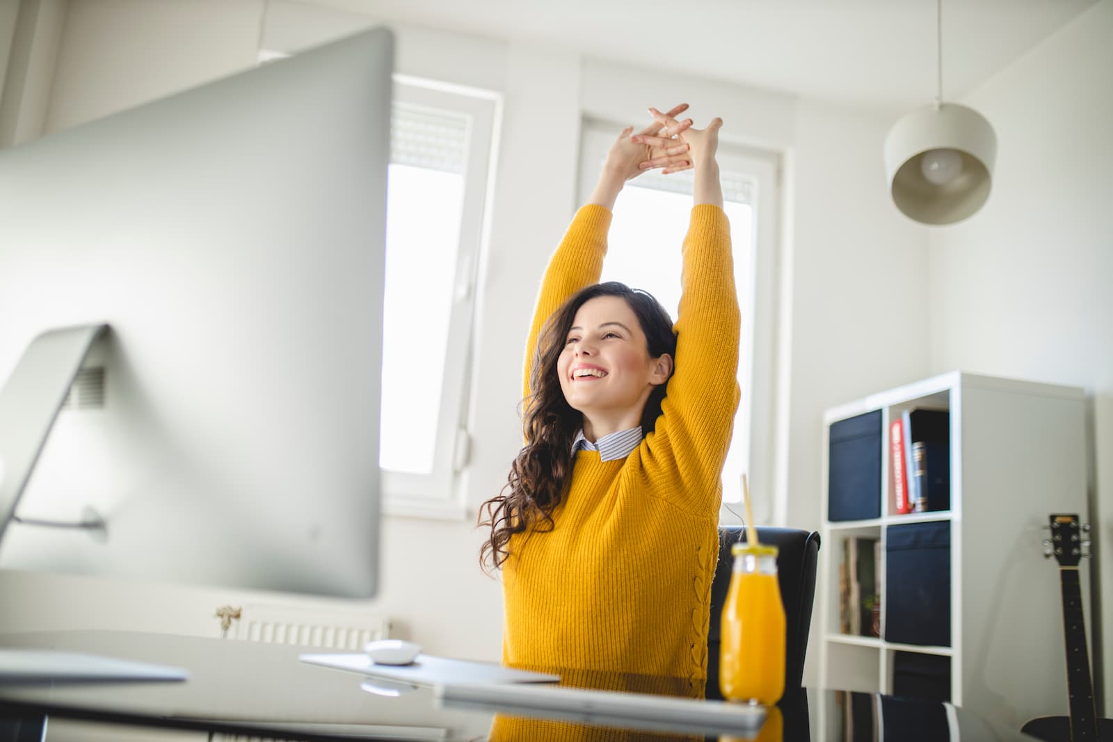 Femme souriante qui s'étire à son bureau