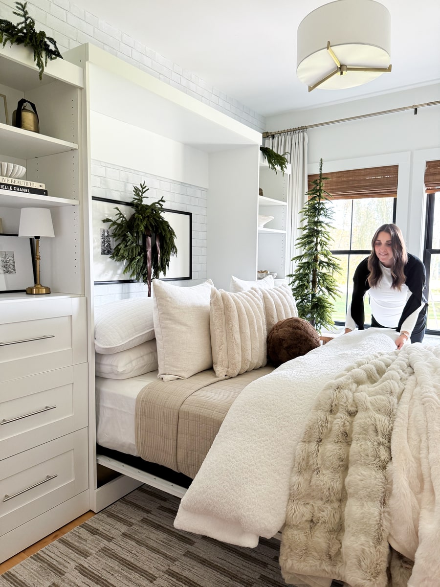 Woman arranging the bed sheets on the Pur Murphy bed with storage