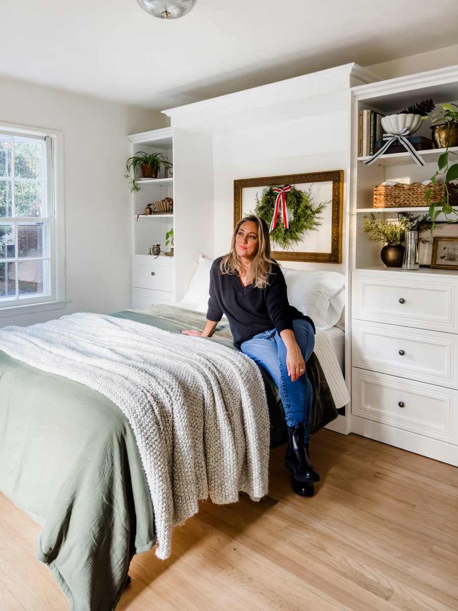 Woman sitting on an Versatile collection Murphy bed with storage